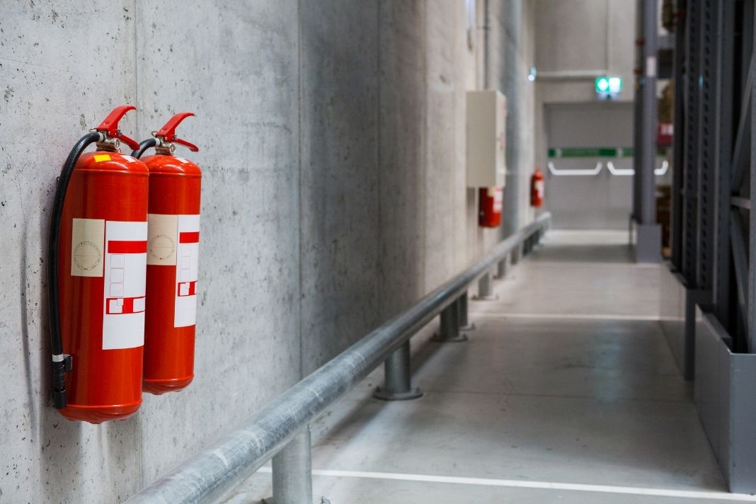 Fire extinguishers hooked up against a wall