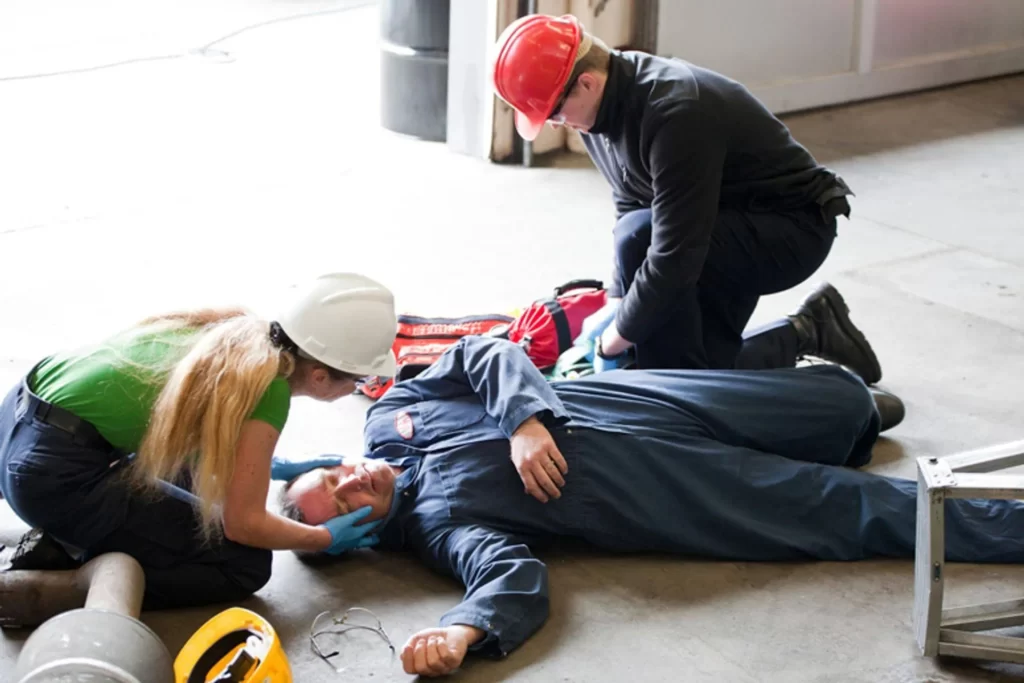Two people providing First Aid to someone unconscious